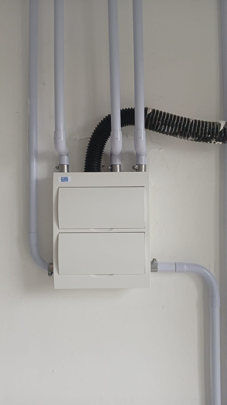 Quadro de distribuição WEG instalado na parede com eletrodutos aparentes bem acabados
